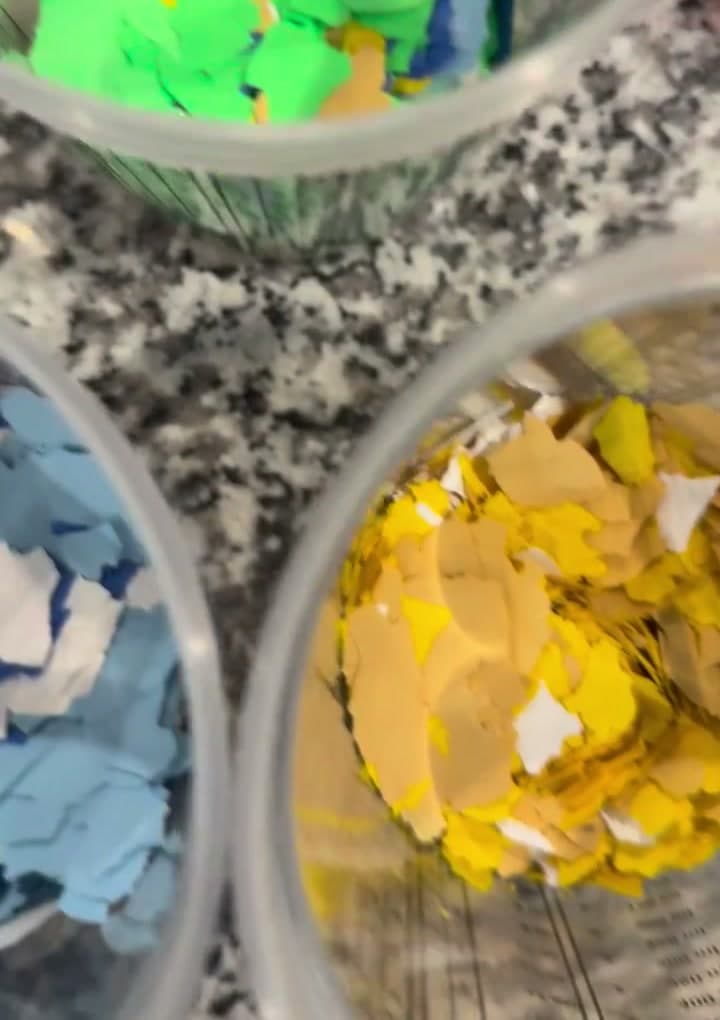 Buckets of bright custom decorative flake colors staged for a custom blend