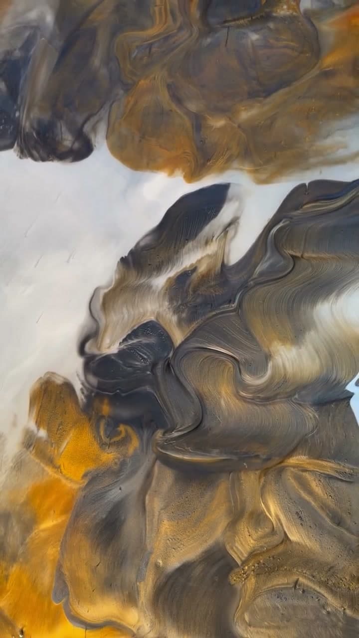 Gold, charcoal, and cream metallic decorative coating being worked with a trowel